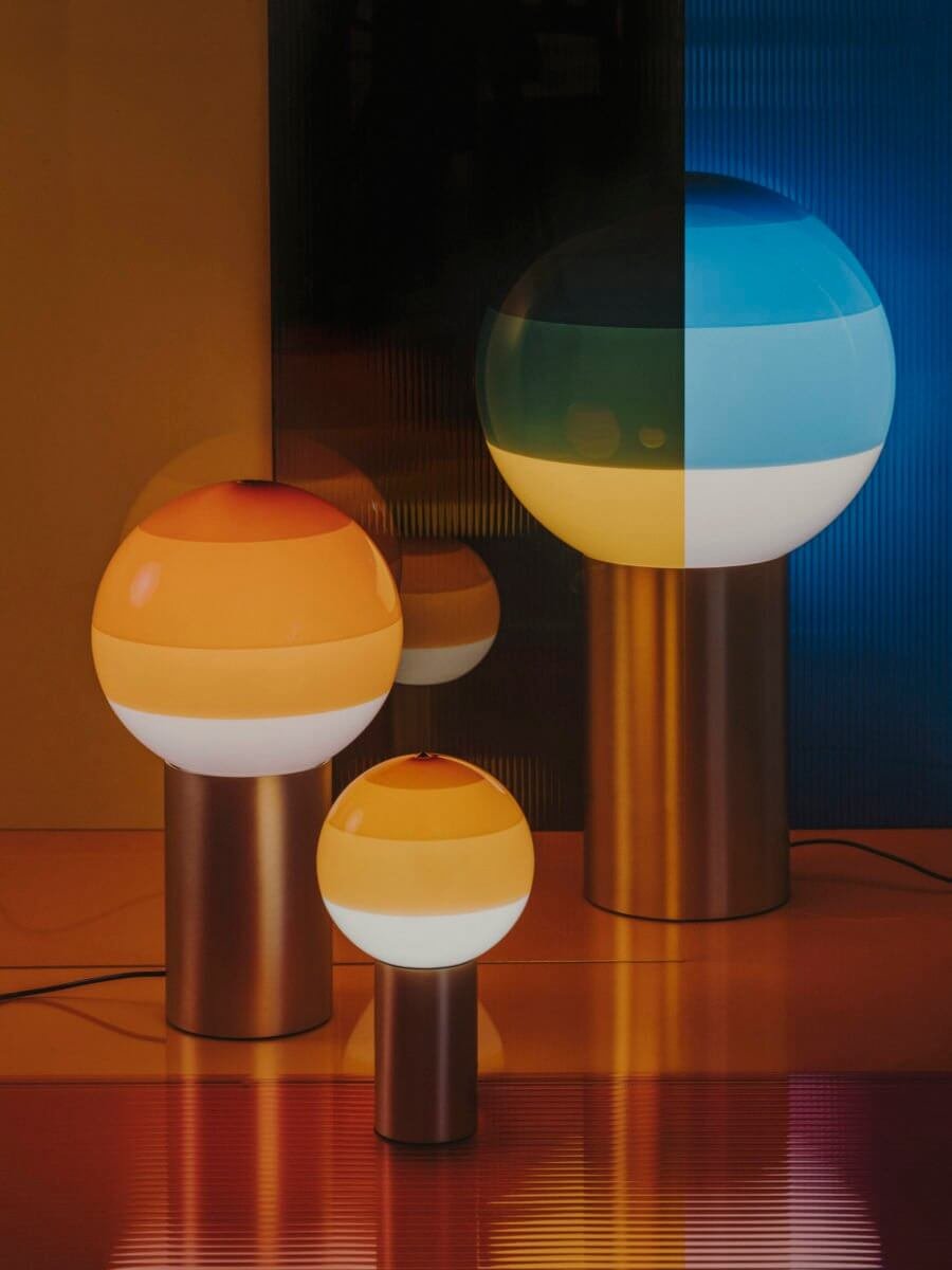 Marset Dipping Light table lamp set in bright striped colors such as blue, orange and green.