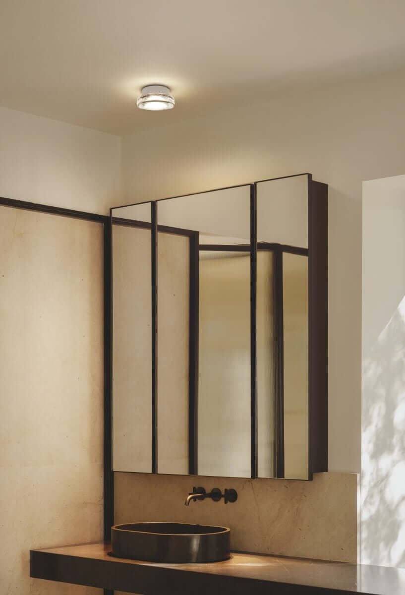 White Marset Roc ceiling lamp with sink and mirror. 